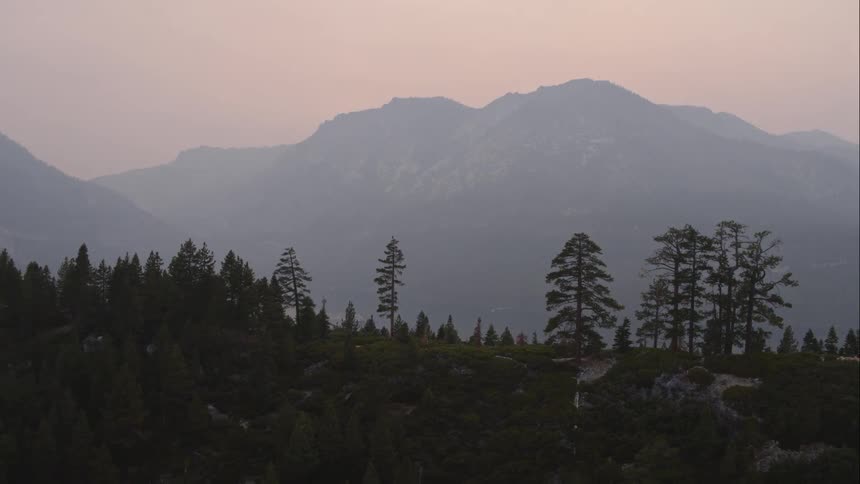 Aerial view of big mountain range next to the lake at dawn