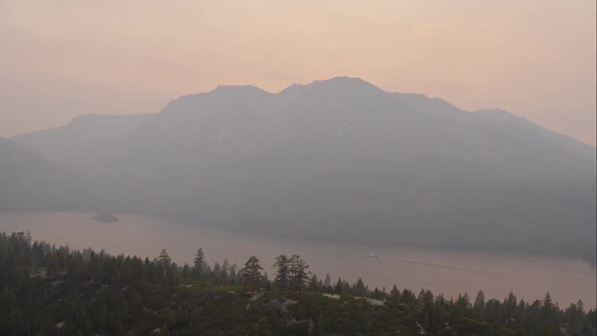 Aerial view of big mountain range next to the lake at dawn