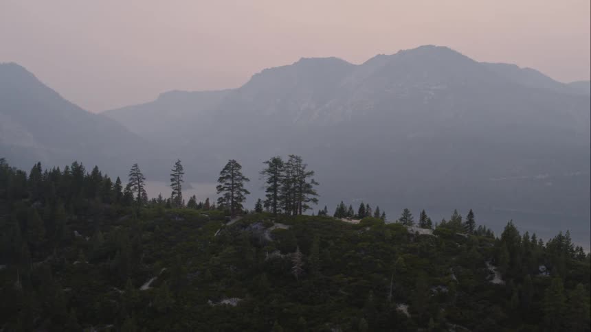 Mountains and forest lined hills surround an ocean inlet
