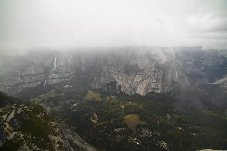 Fog and cloud covered mountain peak with a rainbow
