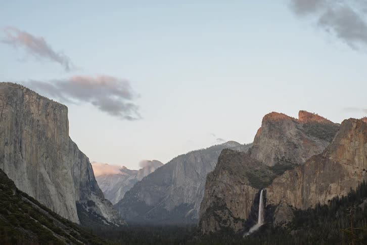 The waterfall is pouring off the mountain ahead