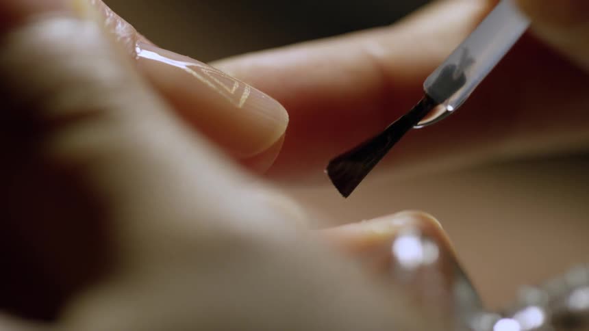 A woman applying nail polish