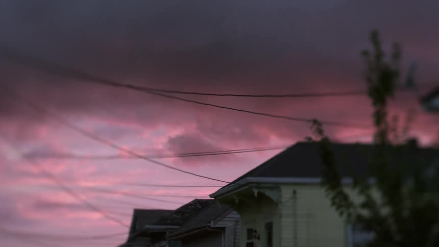 Pink clouds over a row of houses