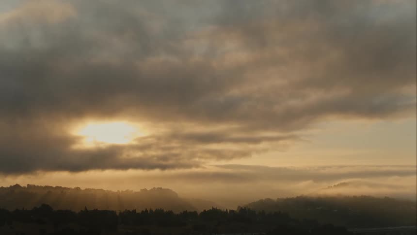 The sun is setting behind the mountains