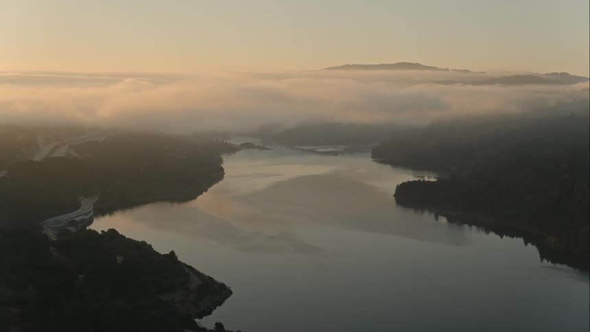 River flows into fog bank on the horizon