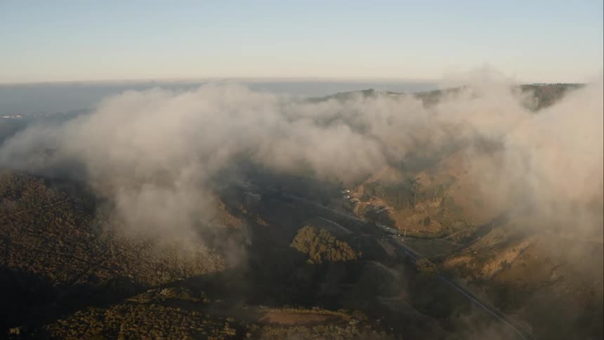 A fog covered canyon leading to the coast