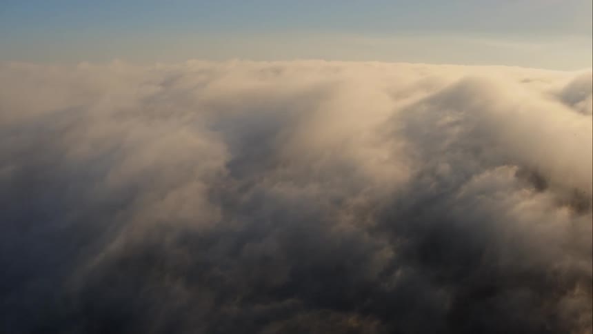 Aerial view of lots of clouds floating in the sky at sunset