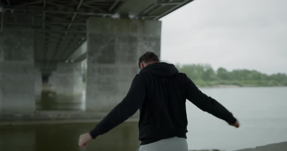 A young man stretches in front of the water
