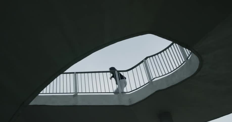 Man in black hoodie runs upstairs on a cloudy day