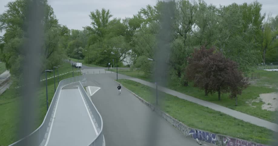 A jogger runs along a paved trail outdoors