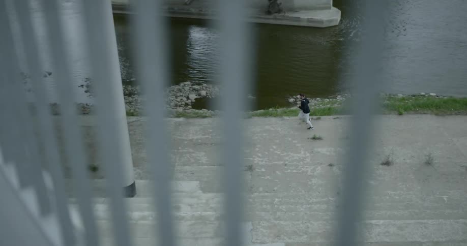 A person running along a paved river bank