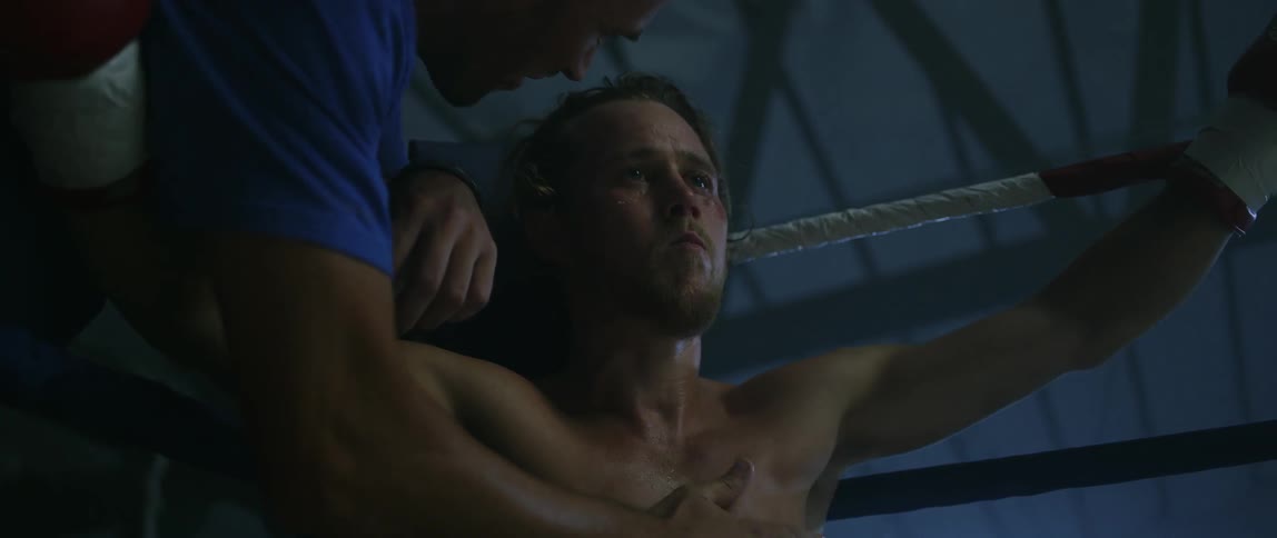 A fighter is being patted on the face and chest in a ring