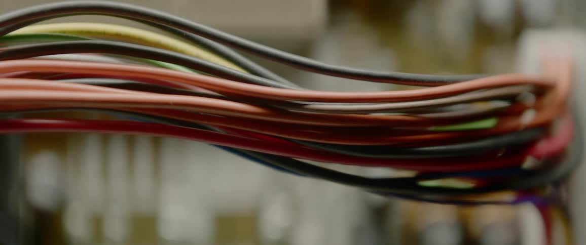 Wires connected to a circuit board illuminated to varying degrees