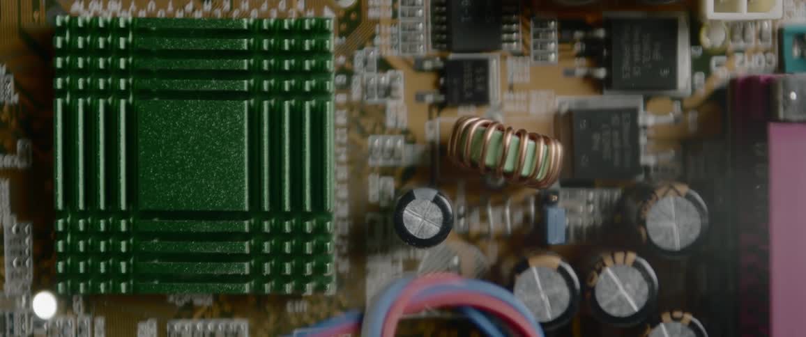 Capacitors and microchips surround a resistor and inductor on a circuit board