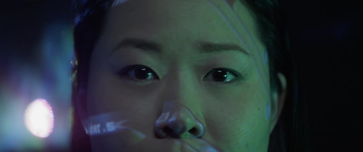 A woman staring with images projected on her face