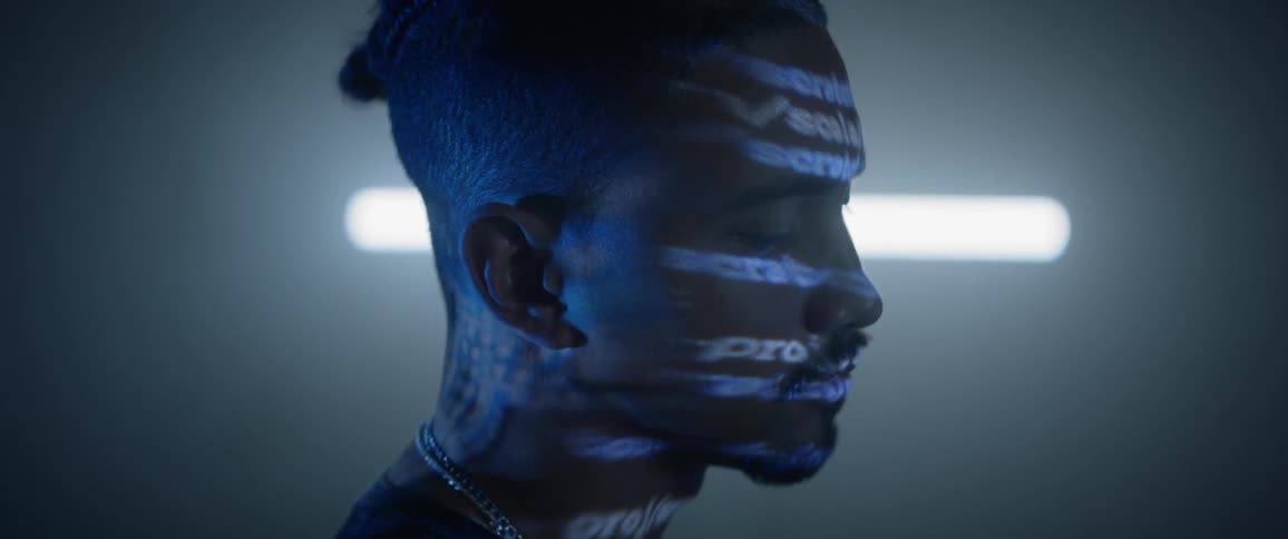 Side profile of man with word projection lighting on his face
