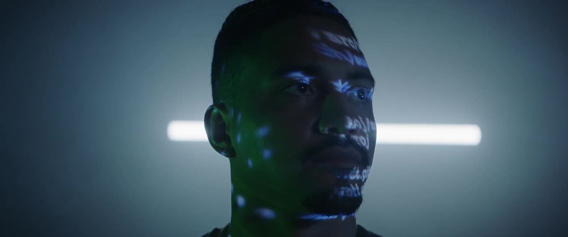 Words and light are projected across a mans face