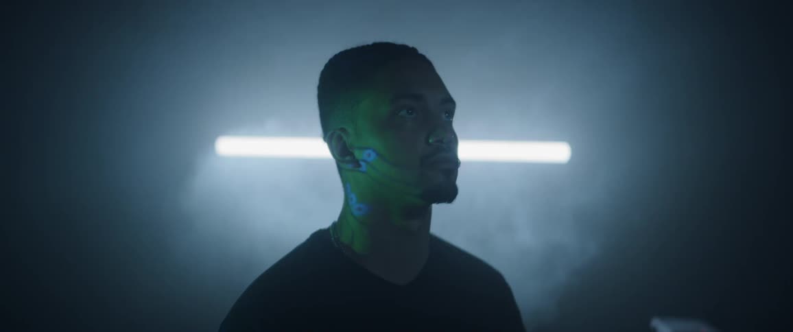 Display reflects images onto face of man standing in smoky dark room