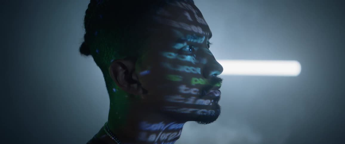 Side view of man with word projection lighting on his face