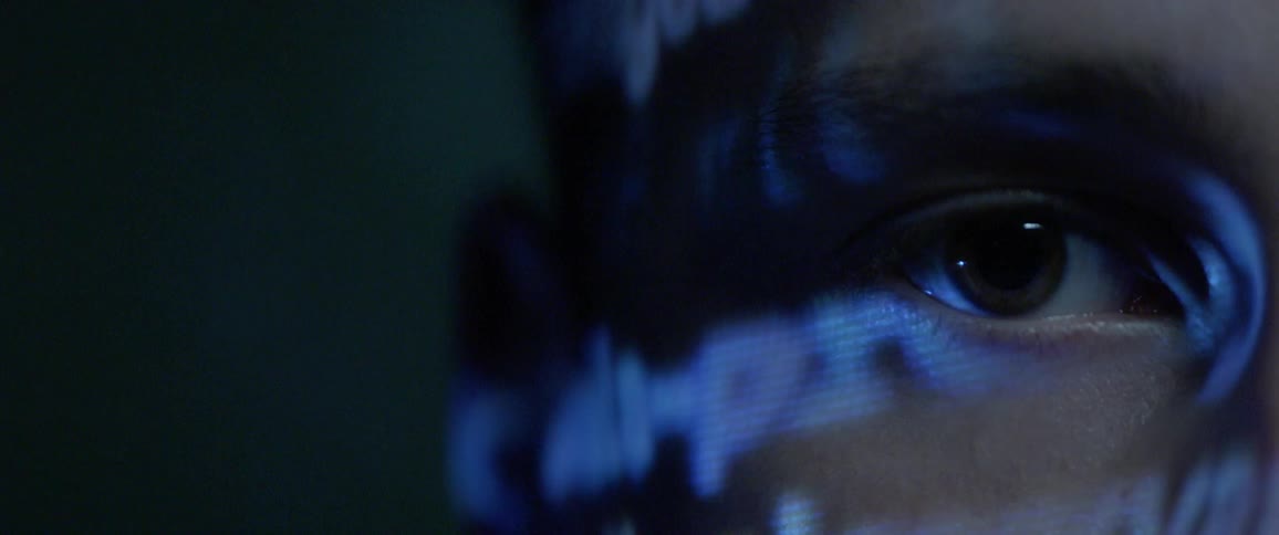 Close up of an eye with word projection lights on side of face
