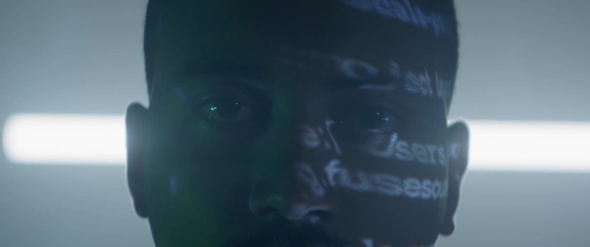 Close up of man with word projection lighting on left side of face