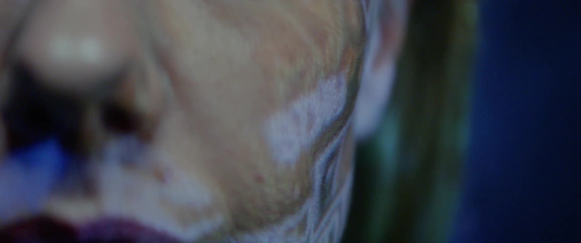 Projected images play over a womans face