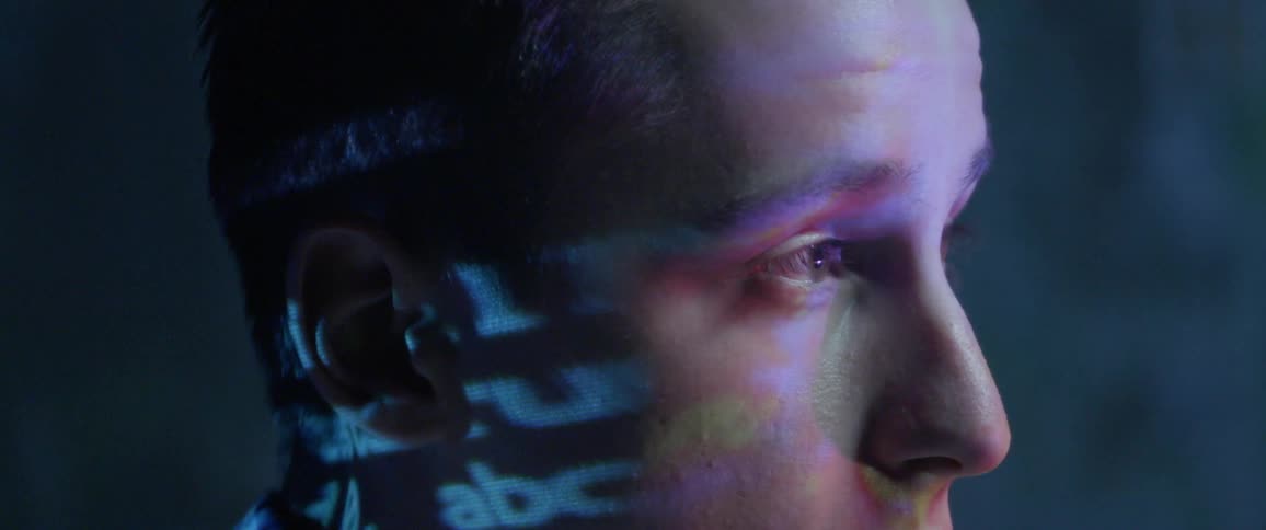 Words are projected onto mans hand as he watches display