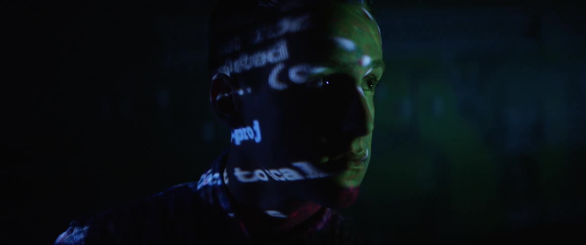 A teenager looks at a screen as the font reflects on him