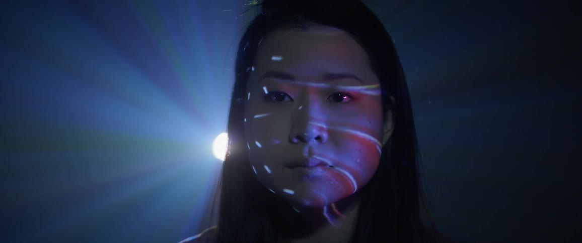 A young asian woman stand while lights flash around her
