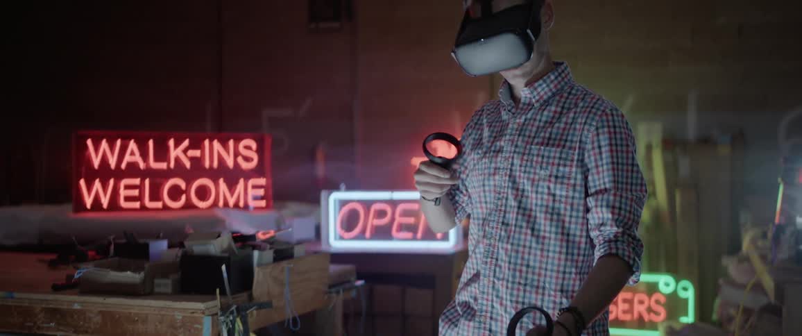 A man wearing virtual reality goggles plays a game