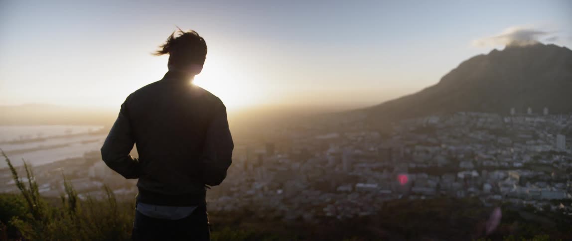 A young man looks down towards the city