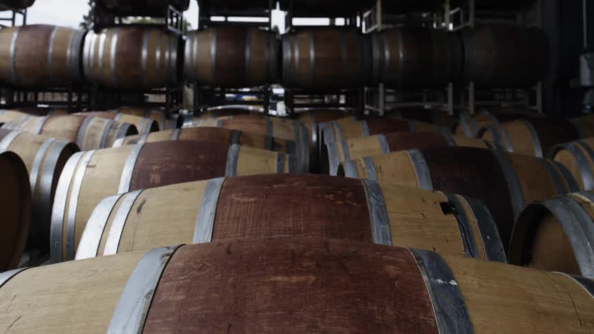 Hundreds of wine casks in rows outside of a building
