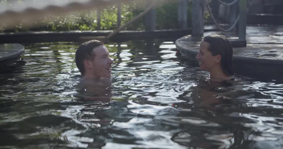 A couple istalking in an outdoor people with plants along the back fence