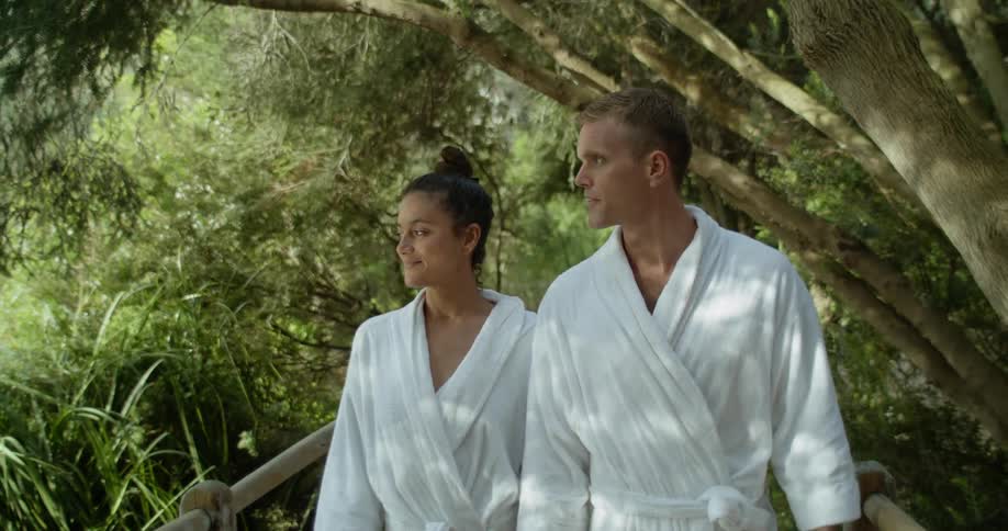 A man and woman in robes walks along a path