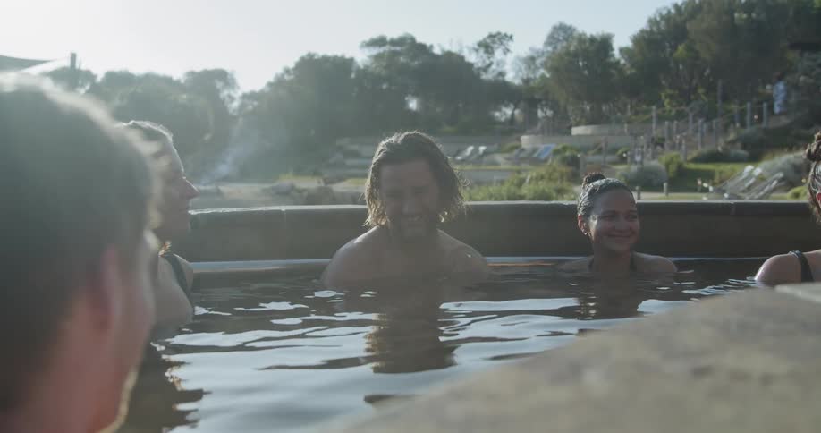 People relaxing outdoors in a hot tub at a resort