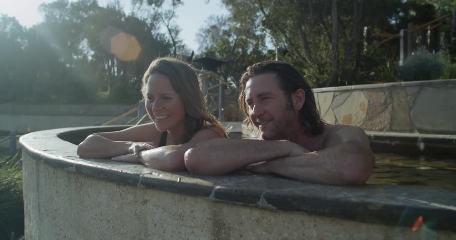 People laughing and talking leaning on the side of a bath spa