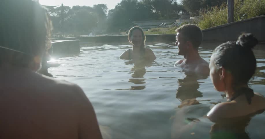 Group of people talk while soaking in outdoors hot spring