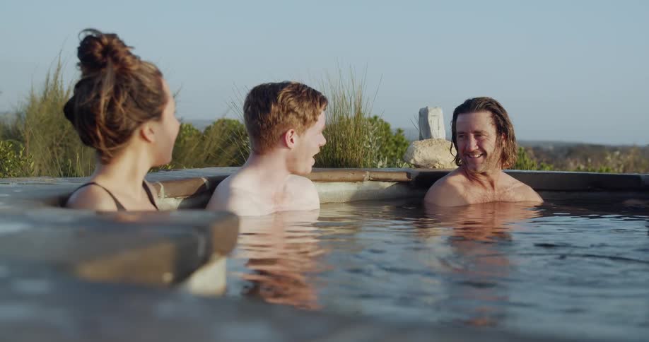 Two men and two women chat in a hot tub