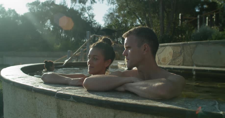 People relaxing in a bath spa pool surrounded by trees