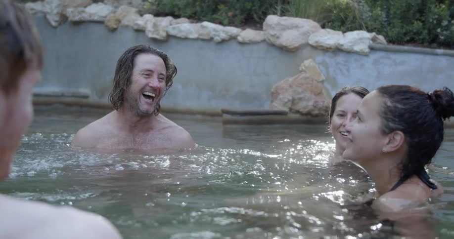 Men and women talk and laugh in the spa water