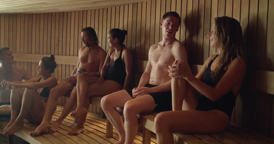Friends sitting on sauna talking to each other