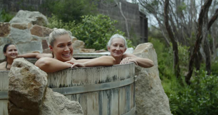People chat in a hot tub outdoors