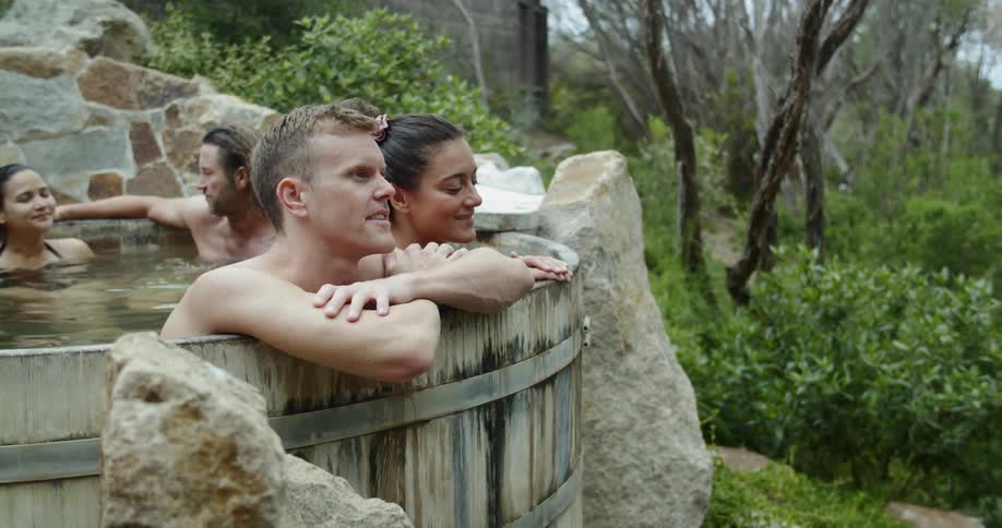 People relaxing in a kind of thermal bath surrounded by bushes