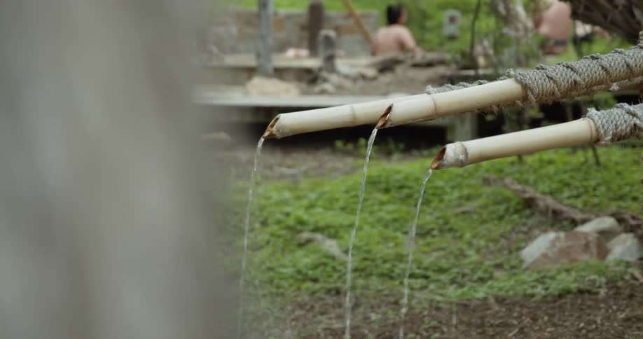 Water trickles from a few cut bamboo stalks that are tethered together