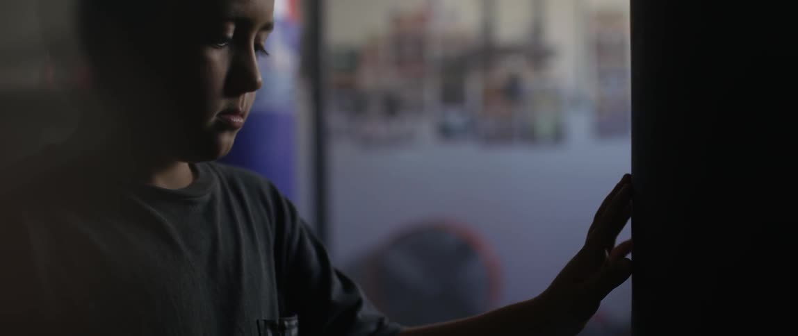 A boy touches a pole in a gym