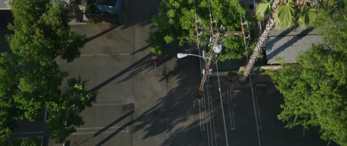 Aerial view of a neighborhood with a man running down the street