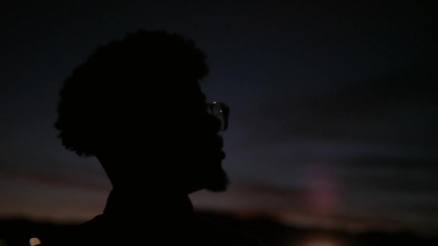 A man looks up at the dawn sky