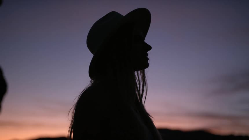 A woman is looking around at the dawn sky