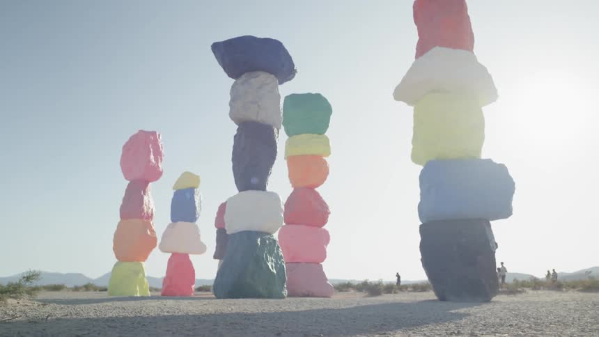 Colorful rock pillars stand in a desert on a sunny day
