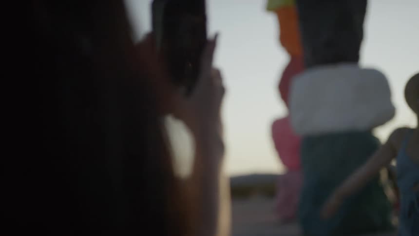 A young woman takes a picture of another woman with her cell phone